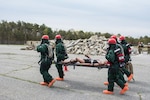 A National Guard search and extraction team carries a dummy away from a collapsed structure as part of an exercise to test the New England Chemical Biological Radiological Nuclear (CBRN) Enhanced Response Package's (CERF-P) response to a CBRN event at Joint Base Cape Cod, Buzzards Bay, Massachusetts May 16, 2018.