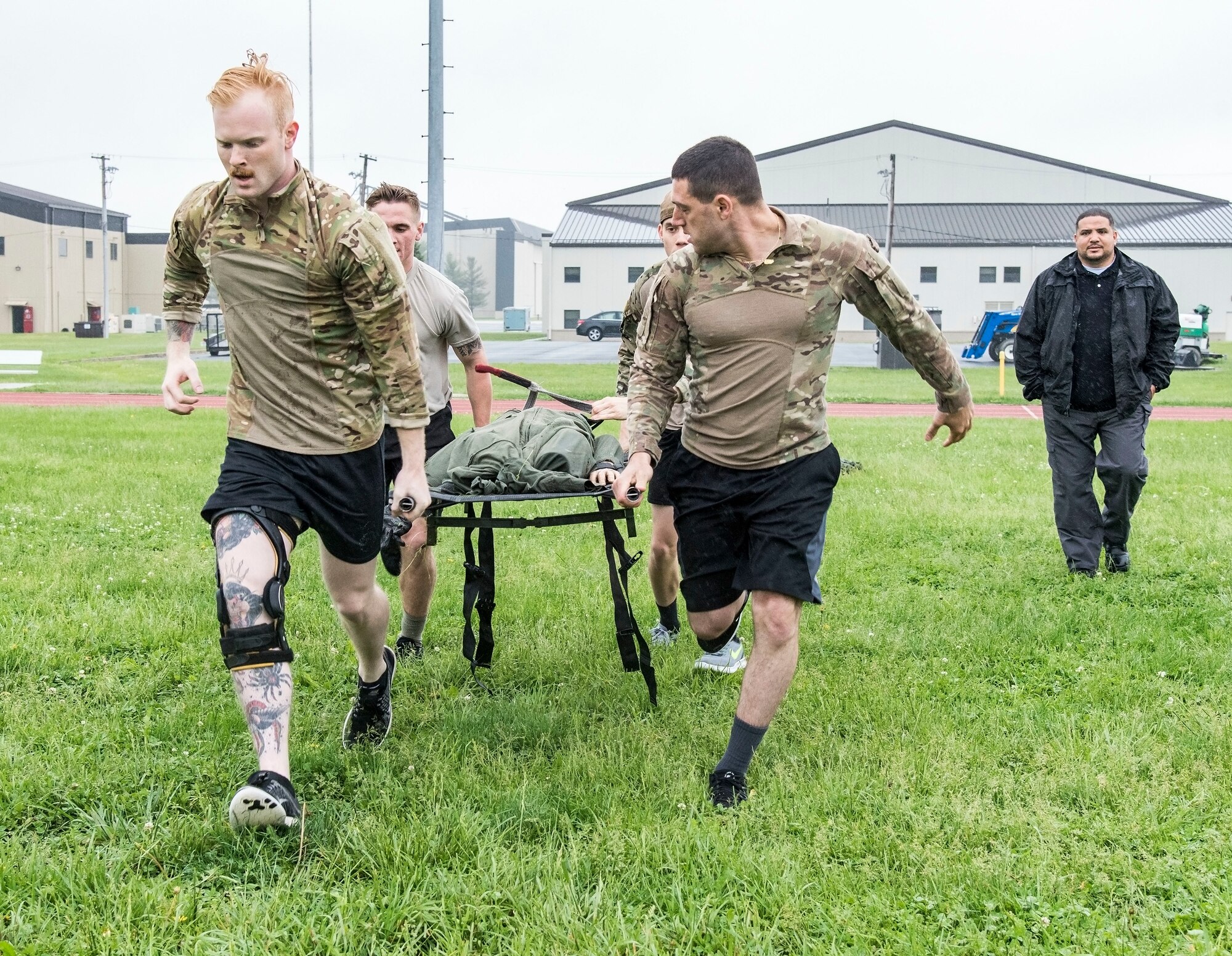 Detective Alex Gonzalez (back right) watches Senior Airman Donald Maas and Airman 1st Class John Paul Zografos, front left to right, followed by Airman 1st Class Hunter Mowery and Jake Goff, rear left to right, all from the 436th Security Forces Squadron, perform the “Rescue Randy Pull” during the Police Week Combat Fitness Challenge May 17, 2018, at Dover Air Force Base, Del. The team finished in first place with a time of 5 minutes and 13 seconds. (U.S. Air Force photo by Roland Balik)