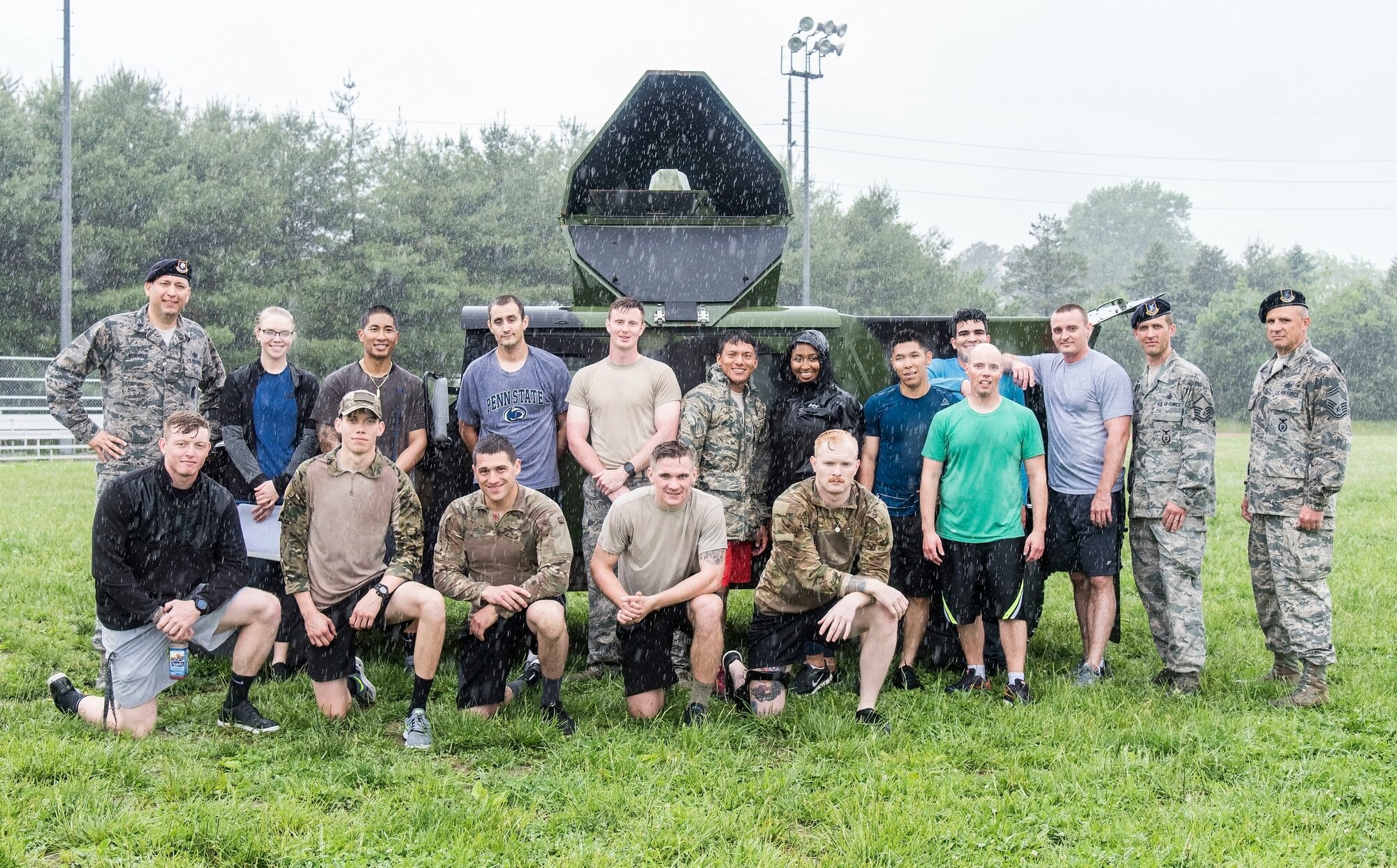 Lt. Col. Michael Morales (left) 436th Security Forces Squadron commander, and Police Week Combat Fitness Challenge participants pose for a photo in the rain after completing the team competition May 17, 2018, at Dover Air Force Base, Del. Morales awarded trophies to the first, second and third place teams. The first place team logged a 9-challenge cumulative time of 5 minutes and 13 seconds. (U.S. Air Force photo by Roland Balik)