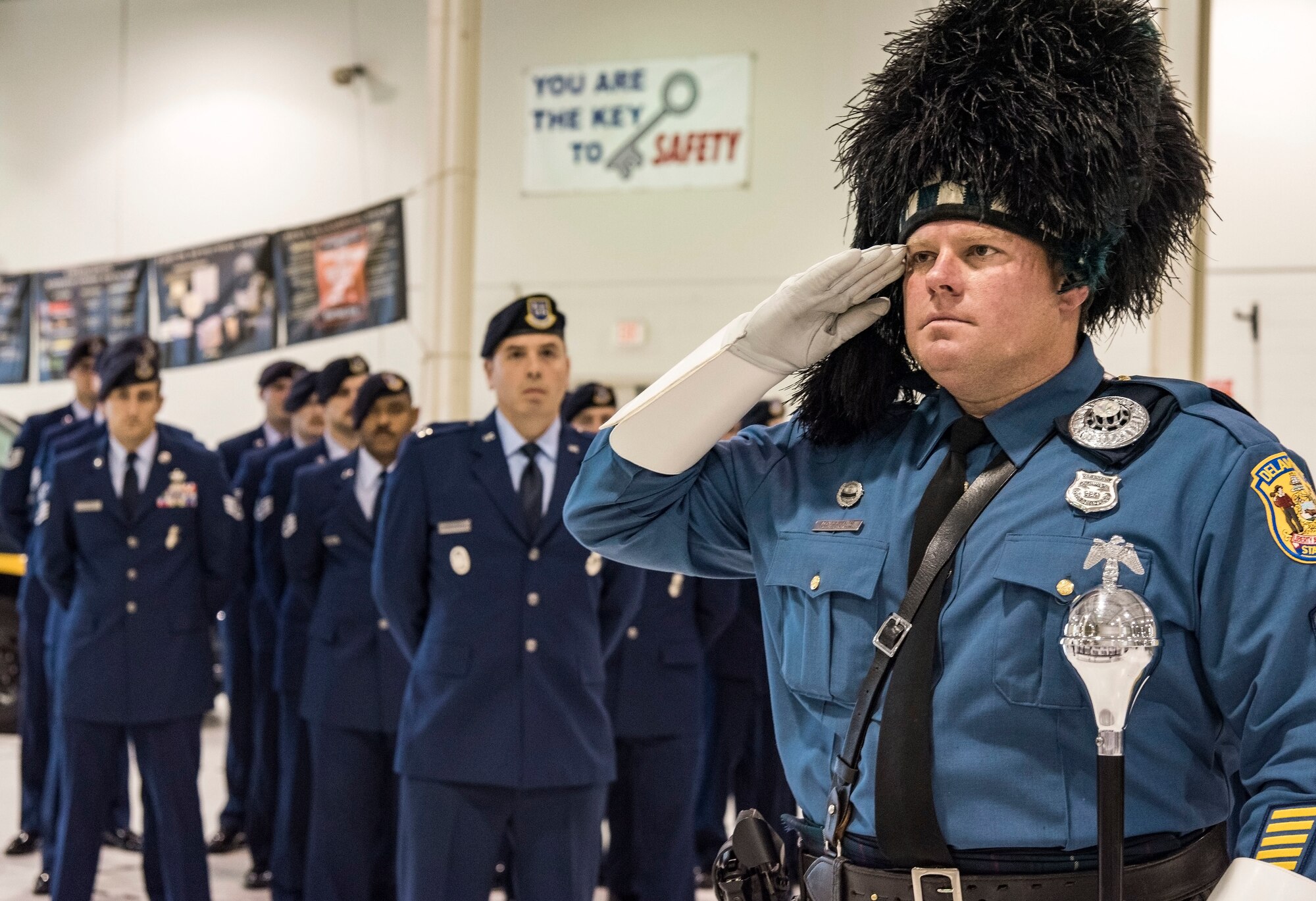 Sgt. Dan Salfas, Delaware State Police Pipes and Drums band drum major, salutes 14 placards during the National Police Week Remembrance Ceremony, May 18, 2018, at Dover Air Force Base, Del. The placards were displayed in honor of Air Force security forces members who died in the line of duty since 2005. The ceremony also recognized 12 Air Force Office of Special Investigation agents who made the ultimate sacrifice in defense of the country. (U.S. Air Force photo by Roland Balik)