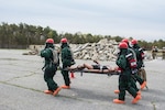 A National Guard search and extraction team carries a dummy away from a collapsed structure as part of an exercise to test the New England Chemical Biological Radiological Nuclear (CBRN) Enhanced Response Package