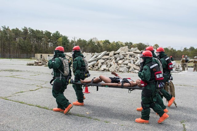 Four National Guardsmen carry a stretcher.
