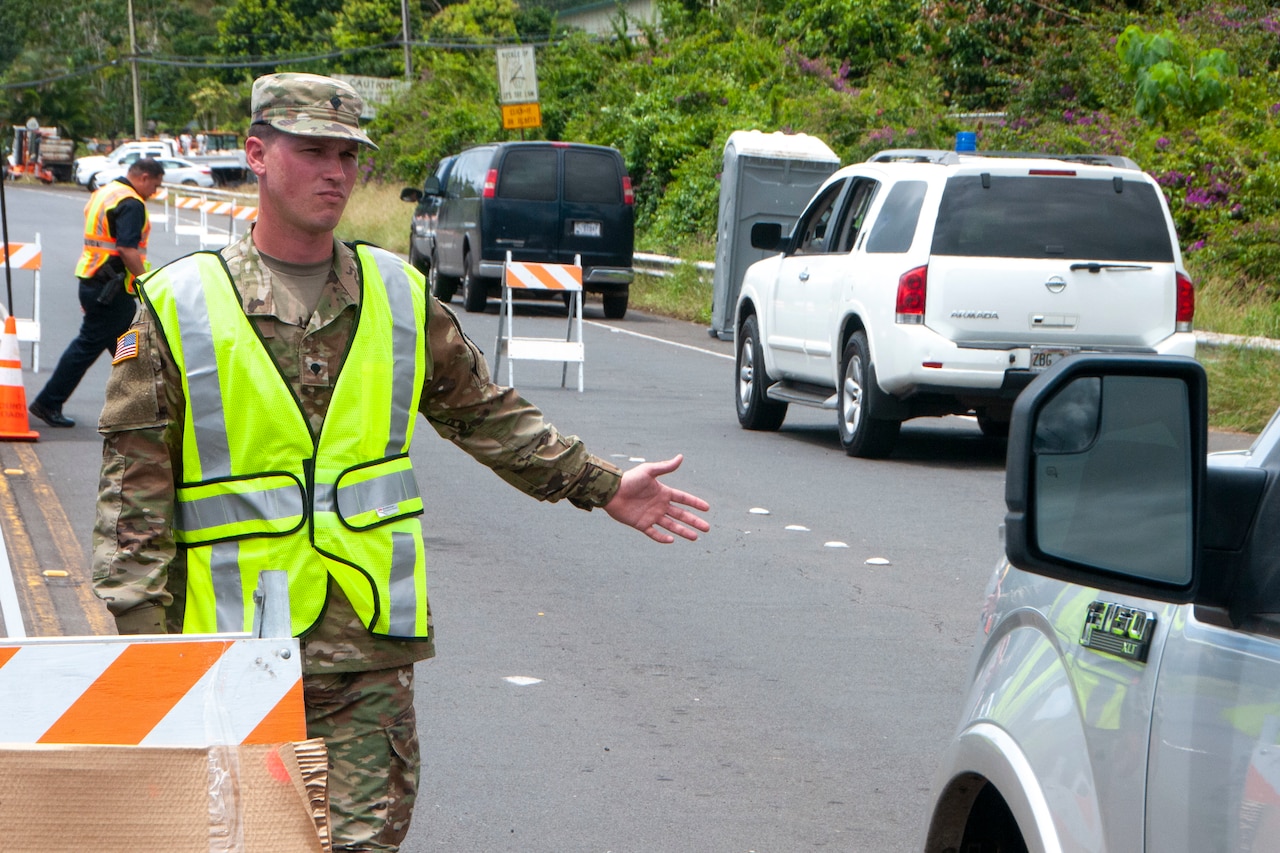 Army Spc. Donavan Wills, a combat engineer with Bravo Company, 227th Brigade Engineer Battalion, directs traffic as part of volcano outbreak response efforts at Leilani Estates, Pahoa, Hawaii.