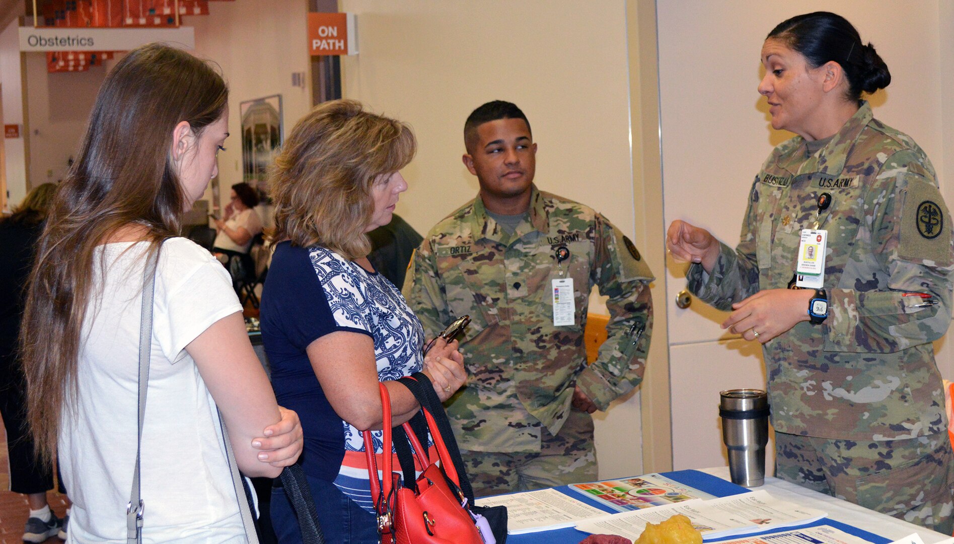 Carolyn and Hannah Wafford talk with Spc. Hector Ortiz and Maj. Brenda Bustillos, chief of education and research branch, at the nutrition table May 19 during the Brooke Army Medical Center Women’s Health Fair.