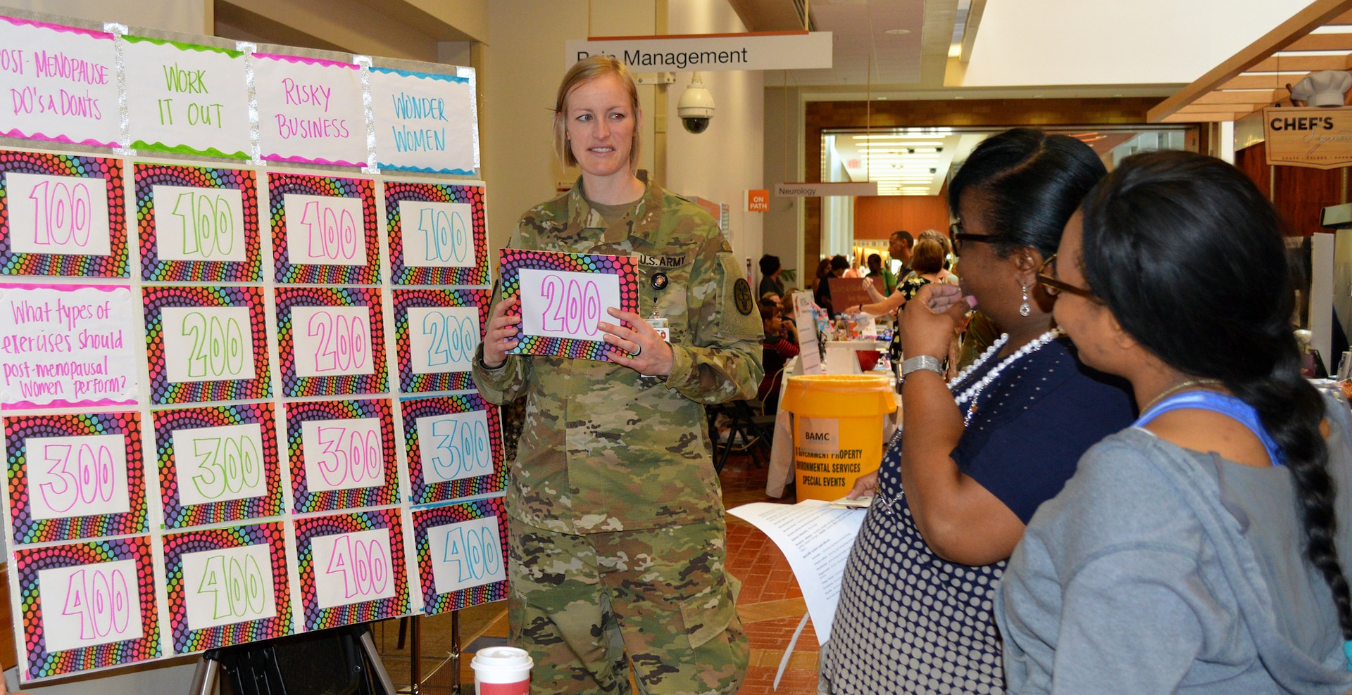 At the physical therapy table, Chanel Jackson and Dorian Mason participate in a game to test their knowledge about exercise during the Women’s Health Fair at Brooke Army Medical Center May 19. The question was “What type of exercises should post-menopausal women perform?” Bobbi Hawthorne, physical therapy student, revealed the answer as “aerobic, strength and balance.”