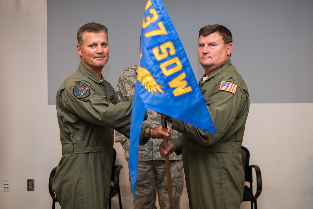 Col. Devin R. Wooden, 137th Special Operations Wing commander (left), and Col. Kelly W. Cobble, outgoing 137th Special Operations Group commander (right), pose with the 137th SOG guide-on during the Group’s change of command ceremony at Will Rogers Air National Guard Base in Oklahoma City, May 17, 2018. Col. Daniel R. “Pinto” Fowler, formerly the Air National Guard's Advisor to U.S. Air Force Special Operations Command, Hurlbert Field, Fla., assumed command with more than 20 years of military experience, including three years as a Joint Terminal Attack Control qualified Air Liaison Officer and 12 years of flying. (U.S. Air National Guard photo by Staff Sgt. Kasey Phipps)