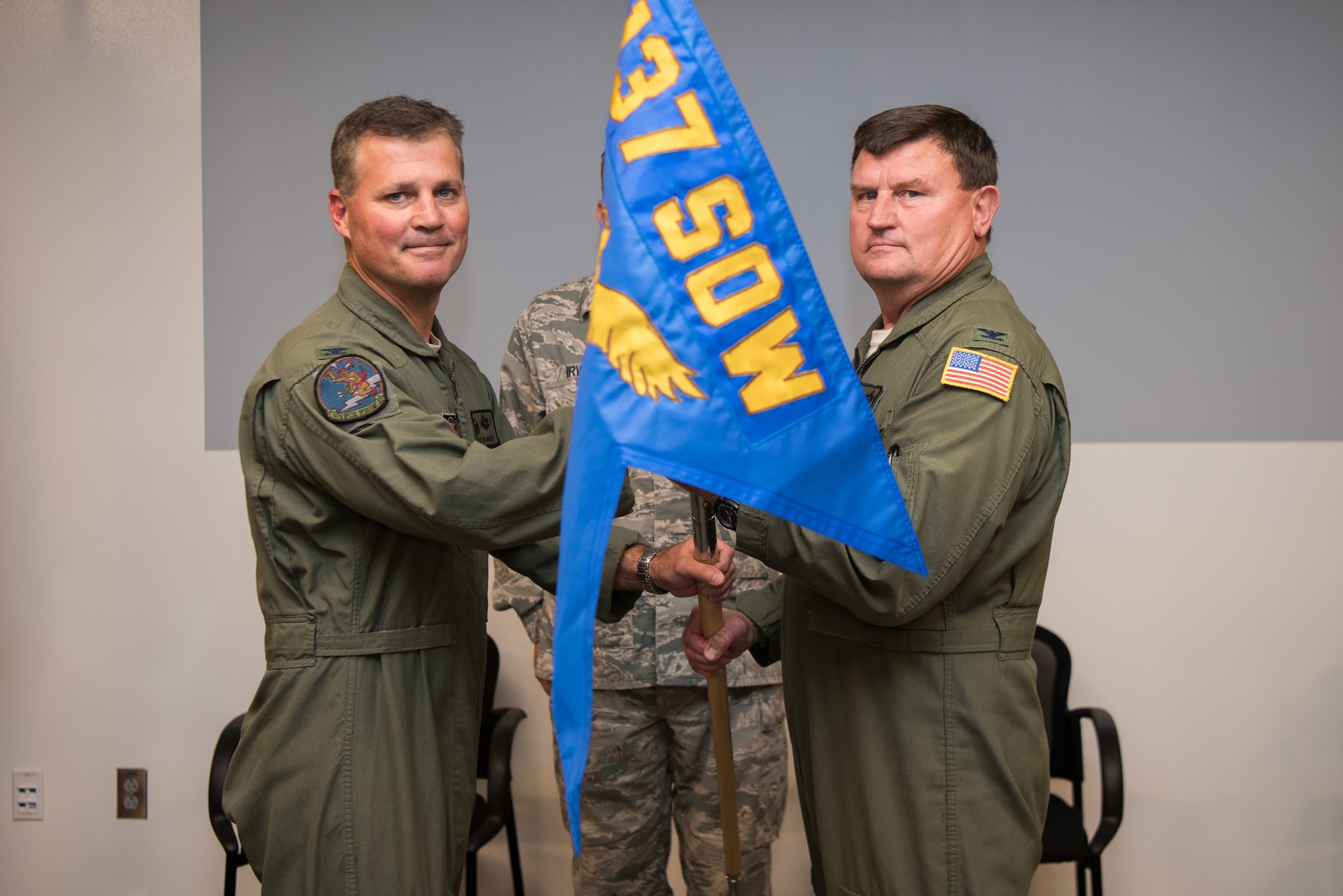 Col. Devin R. Wooden, 137th Special Operations Wing commander (left), and Col. Kelly W. Cobble, outgoing 137th Special Operations Group commander (right), pose with the 137th SOG guide-on during the Group’s change of command ceremony at Will Rogers Air National Guard Base in Oklahoma City, May 17, 2018. Col. Daniel R. “Pinto” Fowler, formerly the Air National Guard's Advisor to U.S. Air Force Special Operations Command, Hurlbert Field, Fla., assumed command with more than 20 years of military experience, including three years as a Joint Terminal Attack Control qualified Air Liaison Officer and 12 years of flying. (U.S. Air National Guard photo by Staff Sgt. Kasey Phipps)
