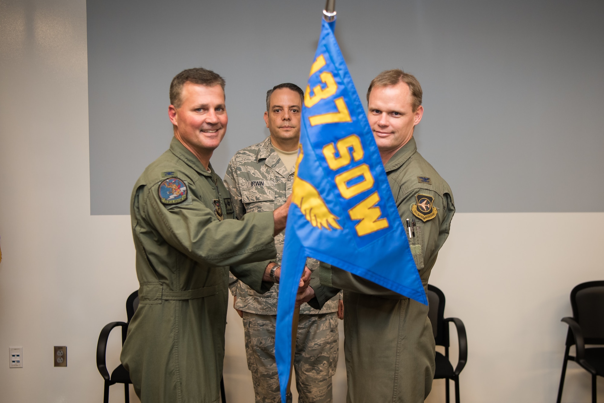 Col. Devin R. Wooden, 137th Special Operations Wing commander (left), and Col. Daniel R. “Pinto” Fowler, incoming 137th Special Operations Group commander (right), pose with the 137th SOG guide-on during the Group’s change of command ceremony at Will Rogers Air National Guard Base in Oklahoma City, May 17, 2018. Fowler, formerly the Air National Guard's Advisor to U.S. Air Force Special Operations Command, Hurlbert Field, Fla., assumed command with more than 20 years of military experience, including three years as a Joint Terminal Attack Control qualified Air Liaison Officer and 12 years of flying. (U.S. Air National Guard photo by Staff Sgt. Kasey Phipps)