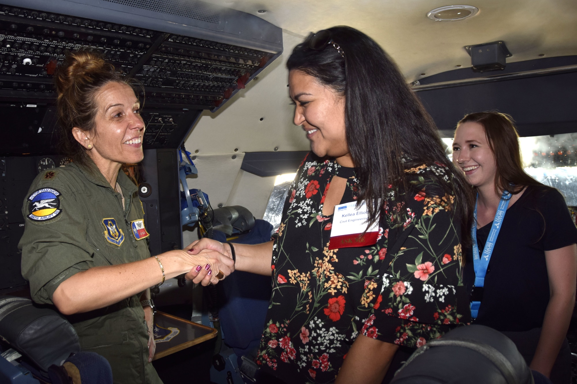 U.S. Air Force Maj. Amy Tullis, 356th Airlift Squadron instructor pilot, shakes hands with Kellea Elliott, an Air Force Personnel Center Premier College Intern Program symposium attendee, while in the C5-M Super Galaxy cockpit during a tour to the 433rd Airlift Wing May 16, 2018, at Joint Base San Antonio-Lackland, Texas. Tullis used her 15 years of piloting experience to brief about the aircraft and answer questions from interns. (U.S. Air Force photo by Tech. Sgt. Iram Carmona)