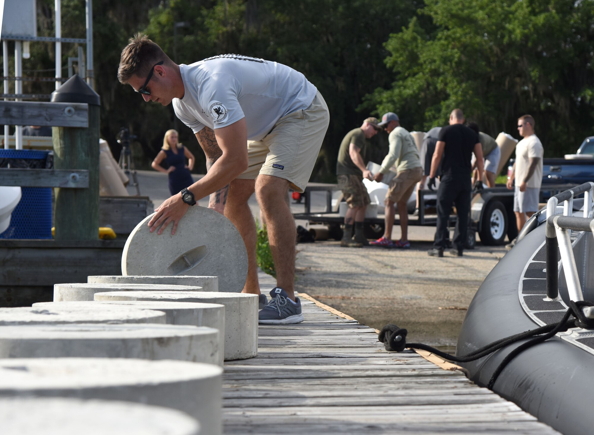 U.S. Air Force Staff Sgt. Taylor Wharton, 81st Security Forces Squadron flight chief, rolls a restricted area buoy anchor onto a pier at The Marina at Keesler Air Force Base, Mississippi, May 23, 2018. Keesler and the Department of Marine Resources partnered to install 15 buoys in the Biloxi Back Bay 150 feet from the Keesler shore line as an added base security measure. (U.S. Air Force photo by Kemberly Groue)