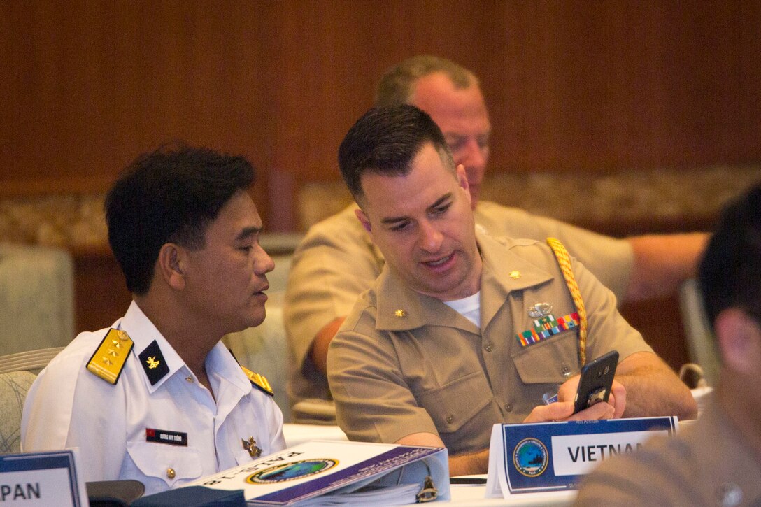 U.S. Marine Corps Maj. Chuck Casey, right, Marine Attaché, Defense Attaché Hanoi, speaks to Vietnamese Capt. Duong Huy Thong, Naval Zone 4, Republic of Vietnam Navy, during the Pacific Amphibious Leaders Symposium 2018 in Honolulu, Hawaii, May 23, 2018. During the symposium, military services from around the world build a closer military-to-military bond with one another. Closer bonds between other militaries facilitate clear lines of communication and foster a spirit of cooperation to meet potential global challenges. (U.S. Marine Corps photo by Sgt. Jonathan E. Lopez Cruet)