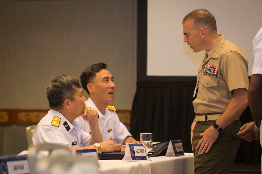 Vietnamese Senior Capt. Le Xuan Thuy, deputy commander, Naval Zone 4, Republic of Vietnam Navy; and Senior Lt. Bui Van Luong, Republic of Vietnam Navy, speak to U.S. Marine Corps Col. Nathan Nastase, assistant chief of staff, G-3/5/7 Division, U.S. Marine Corps Forces, Pacific, during the Pacific Amphibious Leaders Symposium (PALS) 2018 in Honolulu, Hawaii, May 23, 2018. During the symposium, military services from around the world build a closer military-to-military bond with one another. Closer bonds between other militaries facilitate clear lines of communication and foster a spirit of cooperation to meet potential global challenges. (U.S. Marine Corps photo by Sgt. Jonathan E. Lopez Cruet)