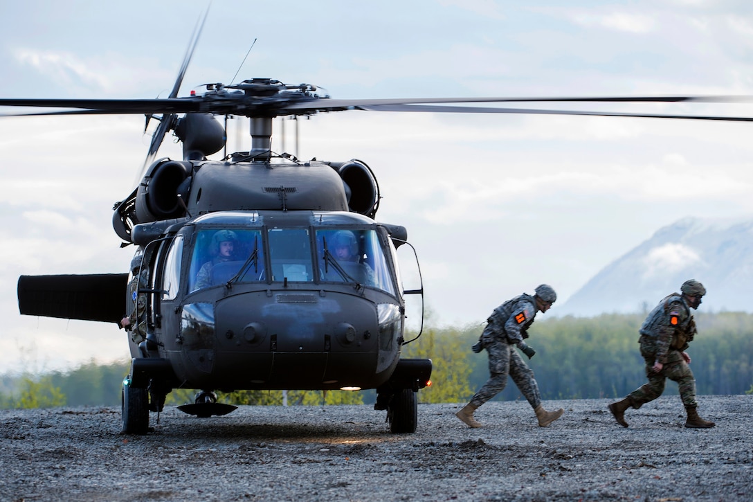 Soldiers exit a UH-60 Black Hawk helicopter.