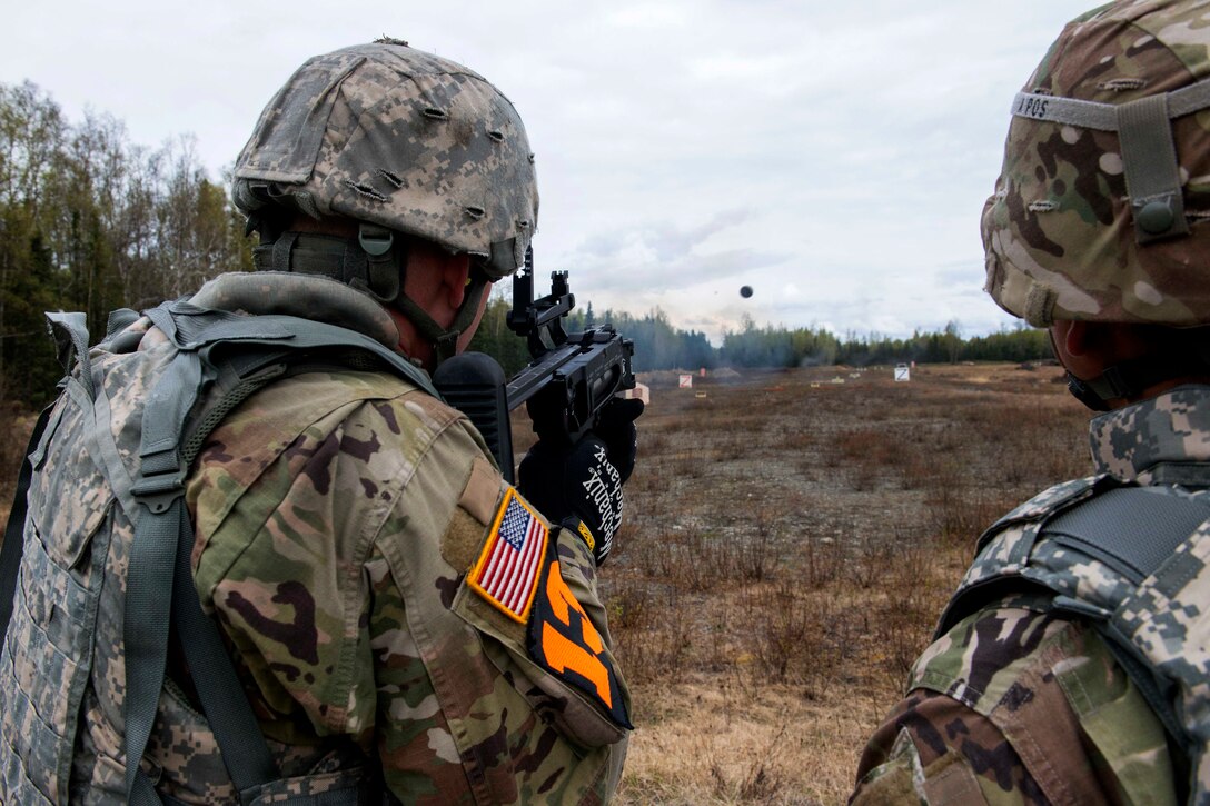 A soldier fires the M320 grenade launcher at targets.