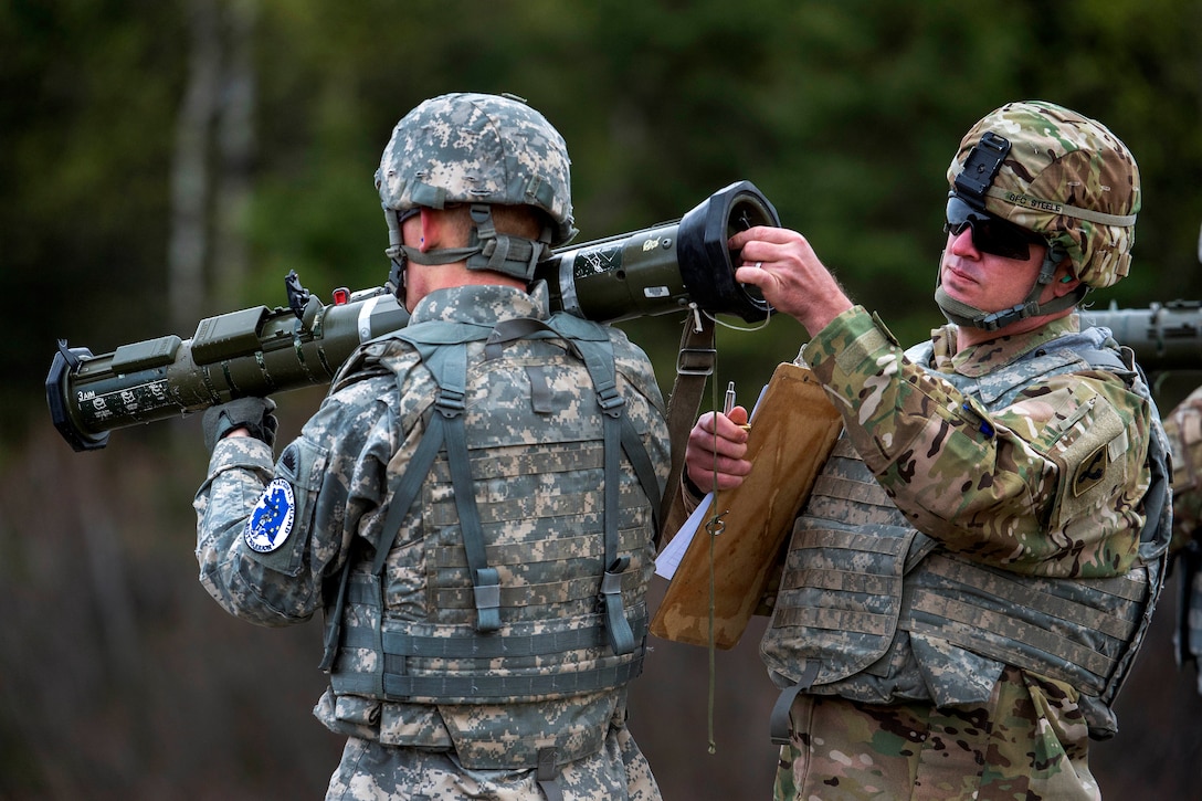 Soldiers prepare a sub-caliber tracer for an AT-4 rocket launcher.