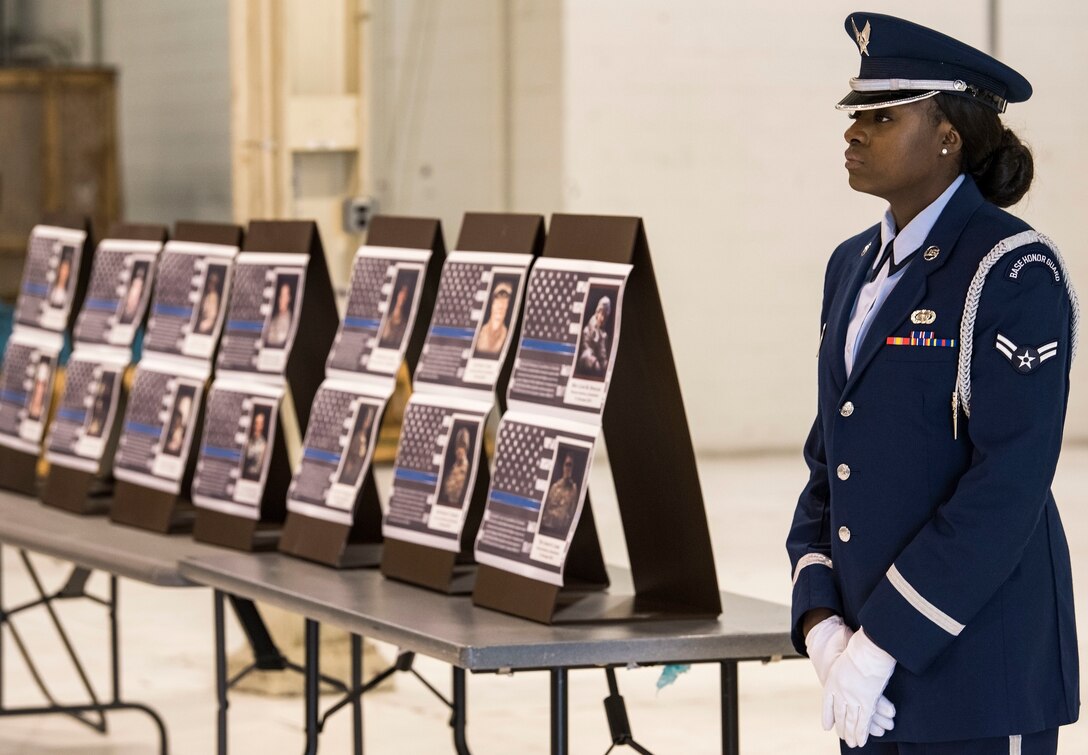 Airman 1st Class Bervely Maxis, 436th Airlift Wing Base Honor Guard member, stands at parade rest prior to the start of the National Police Week Remembrance Ceremony May 18, 2018, at Dover Air Force Base, Del. In the background are 14 placards in honor of Air Force security forces members who have died in the line of duty since 2005. (U.S. Air Force photo by Roland Balik)