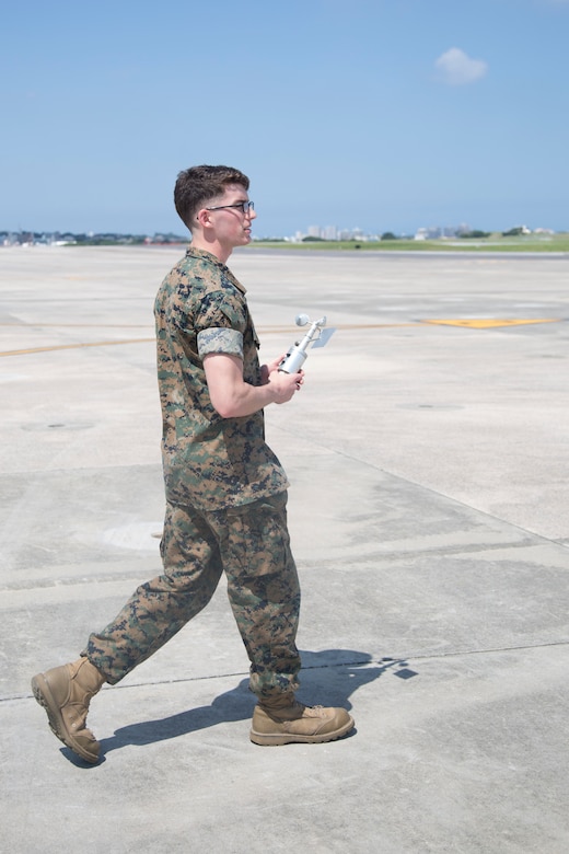 MCAS FUTENMA, OKINAWA, Japan – Lance Cpl. Elijah Davis walks out onto the flight line with a handheld anemometer May 15 aboard Marine Corps Air Station Futenma, Okinawa, Japan.