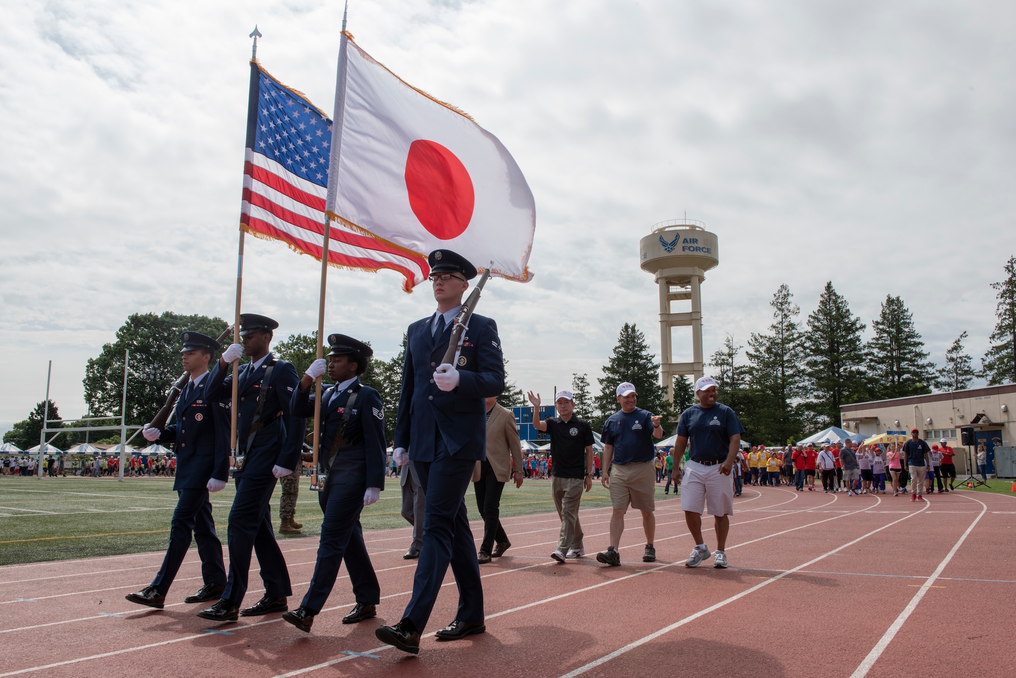Four Airmen carry the colors at the front of the athlete parade during the Kanto Plains Special Olympics at Yokota Air Base, Japan, May 19, 2018.