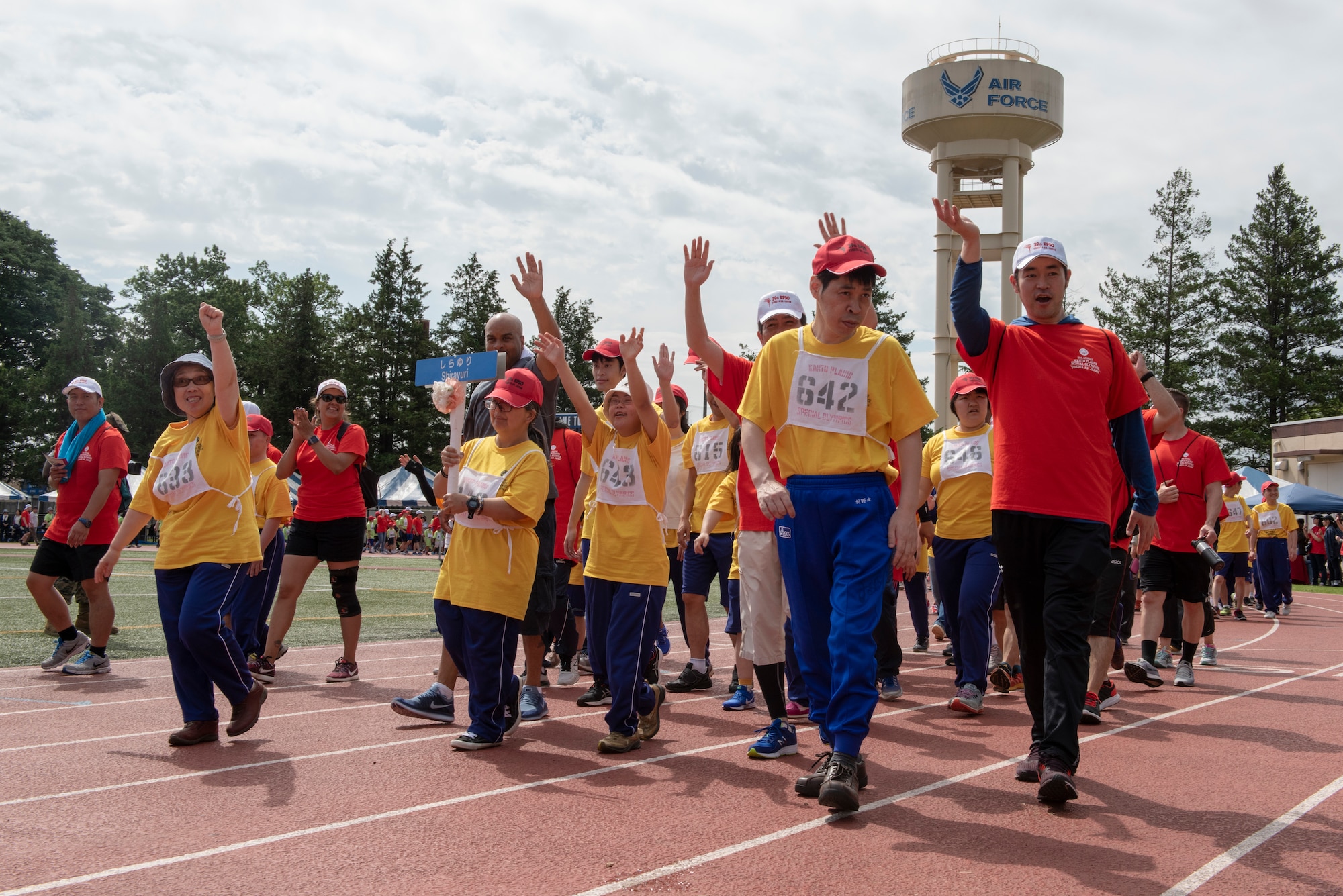 The athletes representing Shirayuri wave to the crowd during the opening parade of the Kanto Plains Special Olympics at Yokota Air Base, Japan, May 19, 2018.