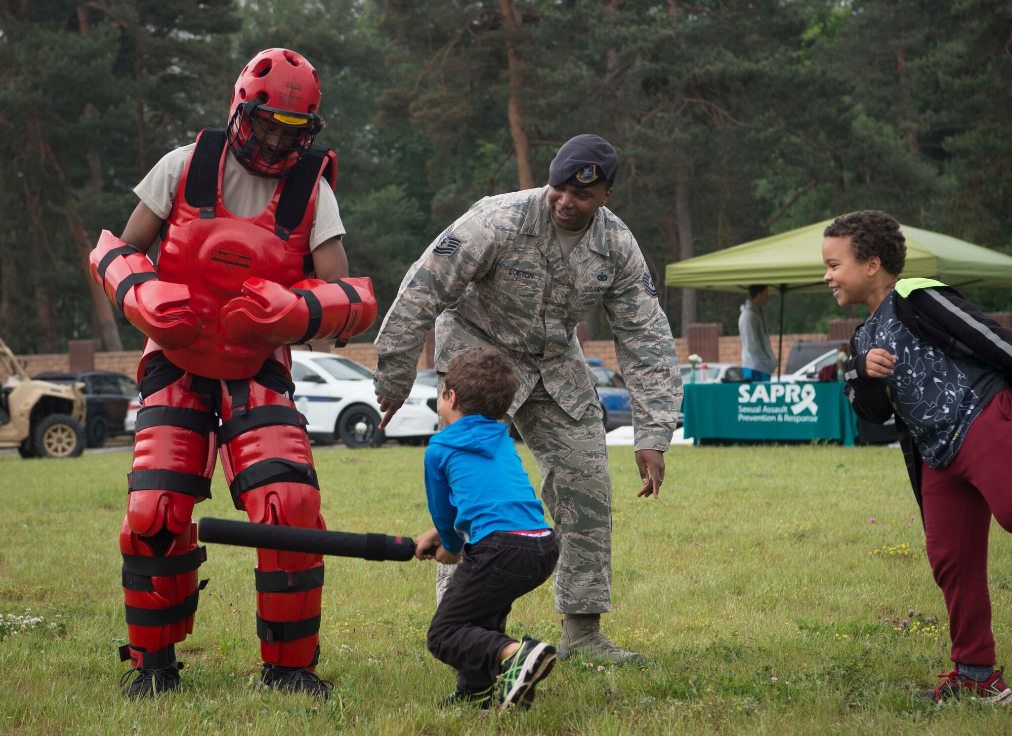 U.S. Air Force Airman 1st Class Deaundrae Ross, left, 86th Security Forces Phoenix Raven team member, wears a “Red Man” suit and invites children to hit him with a padded training baton during Police Week 2018 on Ramstein Air Base, Germany, May 14, 2018. In 1962, President John F. Kennedy signed a proclamation which designated May 15 as Peace Officers Memorial Day, and the week of May 15 as Police Week. (U.S. Air Force photo by Senior Airman Elizabeth Baker)