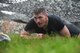 A Kaiserslautern Military Community service member low crawls during the 2018 Ramstein Mudder, May 24 at Ramstein Air Base, Germany. More than 200 Kaiserslautern Military Community Members ran the 2.5 mile obstacle course for the 86th Airlift Wing’s resilience day. (U.S. Air Force photo by Staff Sgt. Nesha Humes Stanton)