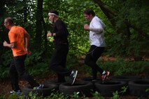 Kaiserslautern Military Community members run through tires during the 2018 Ramstein Mudder, May 24 at Ramstein Air Base, Germany. The fifth annual mudder included 16 stations such as a balance beam, wall climb, low crawl, tire flip and an ammo can relay. (U.S. Air Force photo by Staff Sgt. Nesha Humes Stanton)