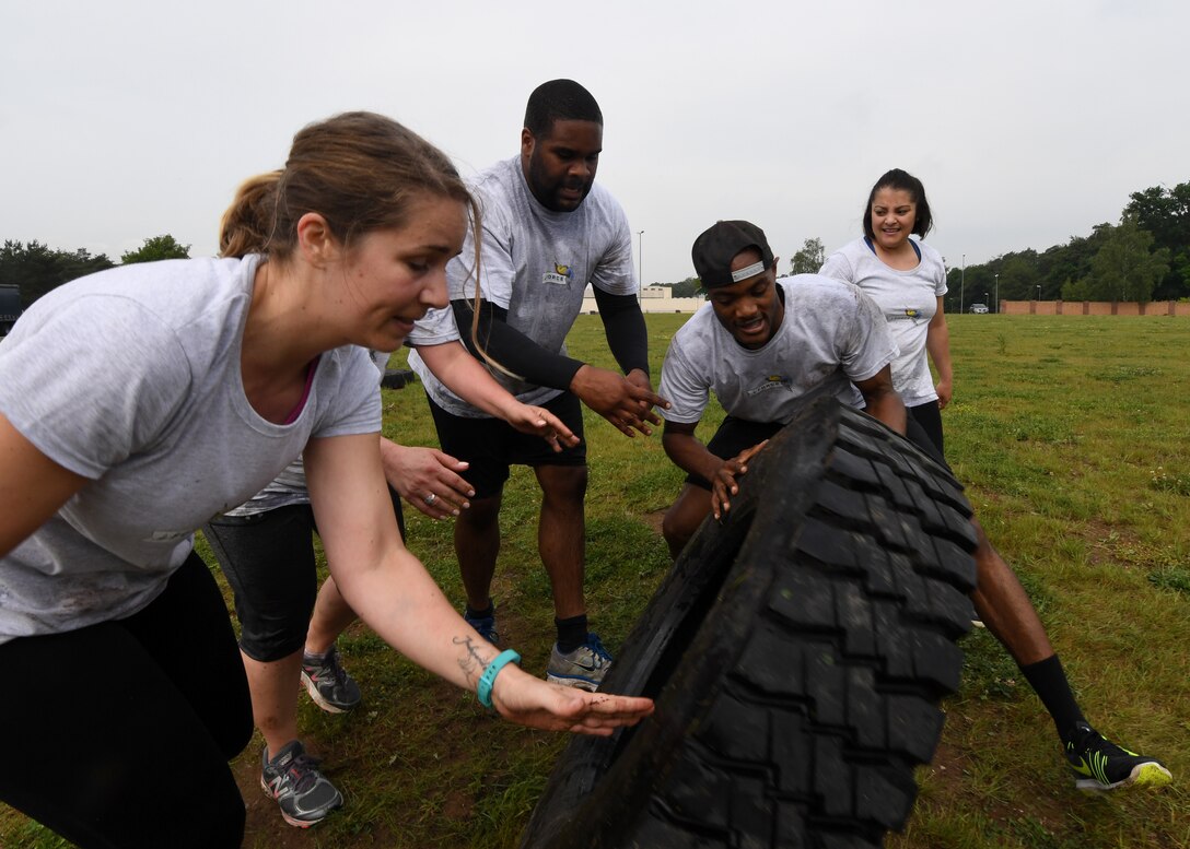 Airmen from the 86 Force Support Squadron flip a tire during the 2018 Ramstein Mudder, May 24 at Ramstein Air Base, Germany. The purpose of the mudder was to promote camaraderie during the 86th Airlift Wing’s resilience day. (U.S. Air Force photo by Staff Sgt. Nesha Humes Stanton)