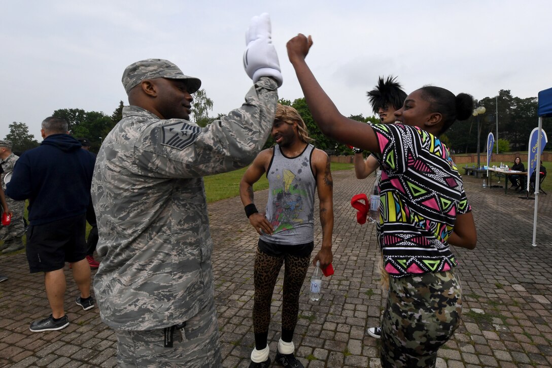 Master Sgt. Antonio Lindsay 569th United States Forces Police Squadron first sergeant, high-fives Airman 1st Class Tori Freeman, 86th Comptroller Squadron financial operations flight customer service technician during the 2018 Ramstein Mudder, May 24 at Ramstein Air Base, Germany. This is the fifth year the 86th Airlift Wing has hosted the obstacle course for their annual resilience day. (U.S. Air Force photo by Staff Sgt. Nesha Humes Stanton)