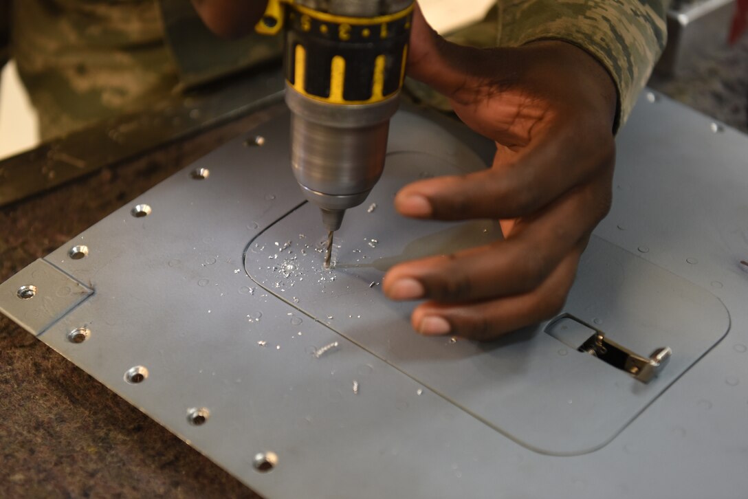A 48th Aircraft Structural Maintenance Airman drills out a rivet to remove a door on a panel at Royal Air Force Lakenheath, England, May 22, 2018. Aircraft Structural Maintainers work on either the flightline, phase inspections or in the main service back shop.