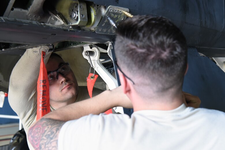 Two 48th Aircraft Structural Maintenance Airmen install a patch on an F-15E Strike Eagle at Royal Air Force Lakenheath, England, May 22, 2018. Aircraft Structural Maintainers are responsible for the skin and skeletal structure of aircraft, as well as the hydraulic systems that affect wing surfaces.