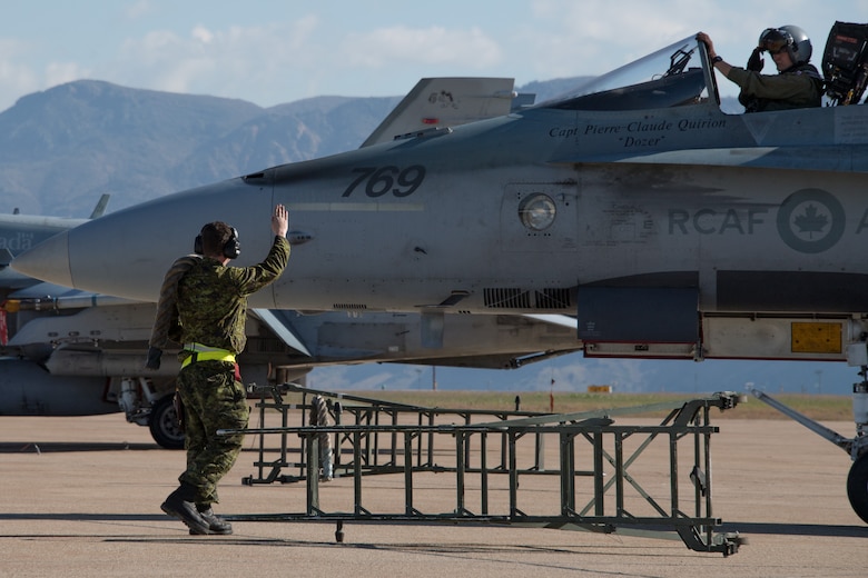 Royal Canadian Air Force structural technician Cpl. Matthew Roy salutes pilot Capt. Jason Berndt, both assigned to the 433rd Tactical Fighter Squadron, before takeoff May 3, 2018, at Hill Air Force Base, Utah. The Canadian unit participated in a Weapons Evaluation Systems Program, or WSEP, exercise conducted by the 86th Fighter Weapons Squadron, a Hill tenant unit. (U.S. Air Force photo by R. Nial Bradshaw)