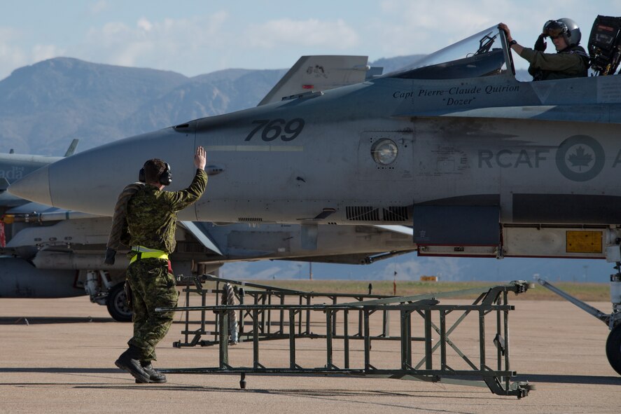 Royal Canadian Air Force structural technician Cpl. Matthew Roy salutes pilot Capt. Jason Berndt, both assigned to the 433rd Tactical Fighter Squadron, before takeoff May 3, 2018, at Hill Air Force Base, Utah. The Canadian unit participated in a Weapons Evaluation Systems Program, or WSEP, exercise conducted by the 86th Fighter Weapons Squadron, a Hill tenant unit. (U.S. Air Force photo by R. Nial Bradshaw)
