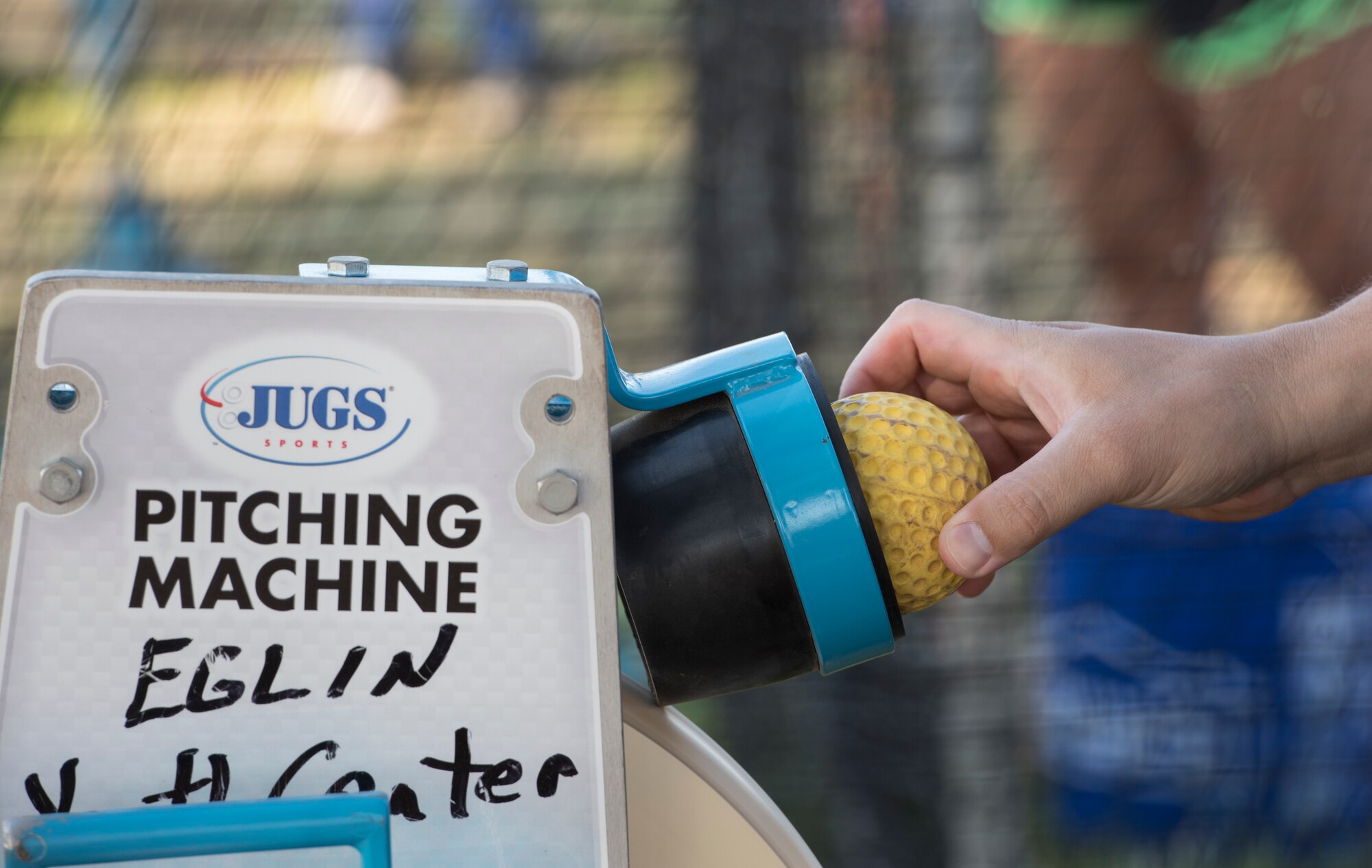 U.S. Air Force Capt. Joshua Gradaille, 33rd Fighter Wing executive officer, places a practice ball in a pitching machine May 10, 2018, at Eglin Air Force Base, Fla. Gradaille's lifelong connection to baseball began as a young boy in Miami Beach, Fla., and eventually led him to coaching his son's team. (U.S. Air Force photo by Staff Sgt. Peter Thompson)