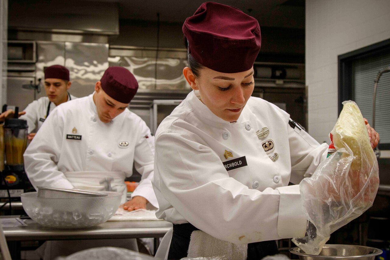 Military chef prepares a dish during a competition.