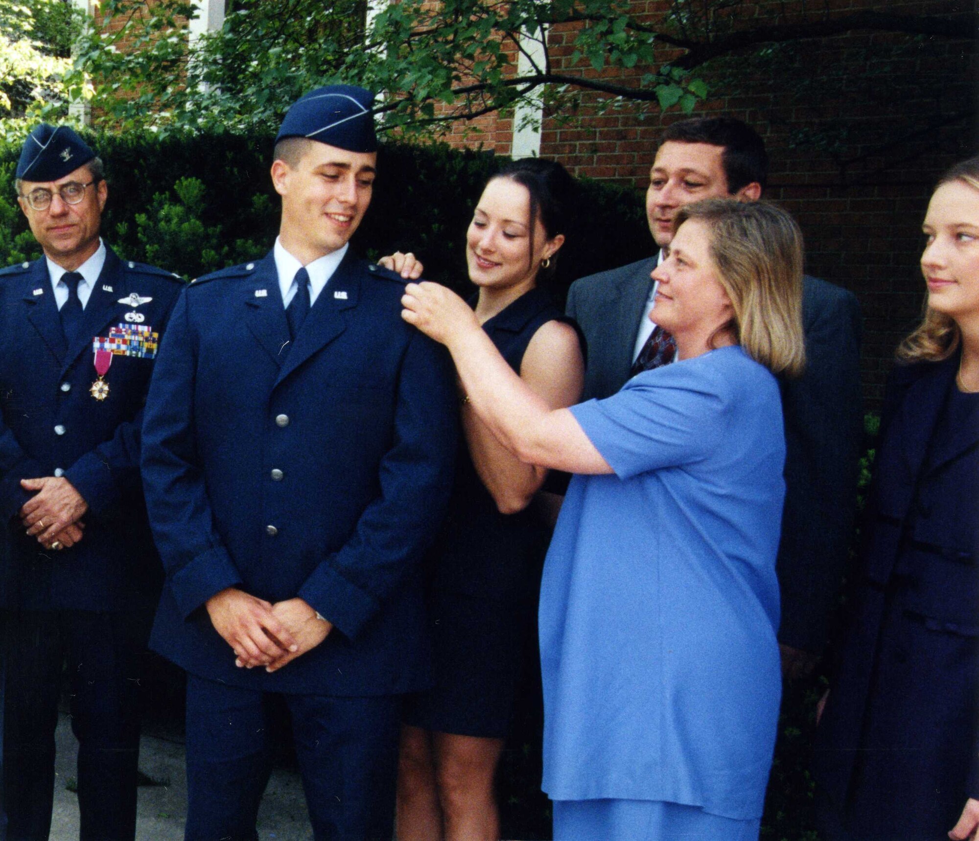 Col. Richard Evans, West Virginia University aerospace science professor and Detachment 915 commander, looks on as 2nd Lt. Dan Cooley, WVU ROTC graduate, gets a gold bar pinned on by his wife, Terese, his father, Chuck, his mother, LouAnn, and his sister, Beth, during his promotion ceremony May 15, 1999.