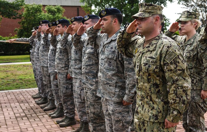 Service members salute the U.S. flag during a retreat ceremony May 18, 2018, at Joint Base Charleston, S.C.
