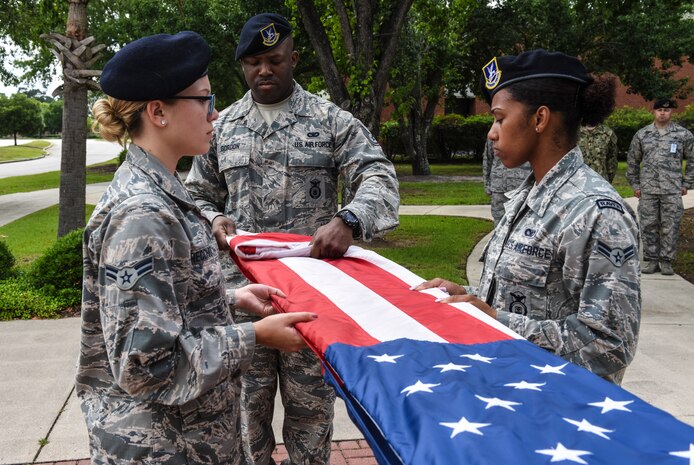 Airmen with the 628th Security Forces Squadron fold the U.S. flag during a retreat ceremony May 18, 2018, at Joint Base Charleston, S.C.