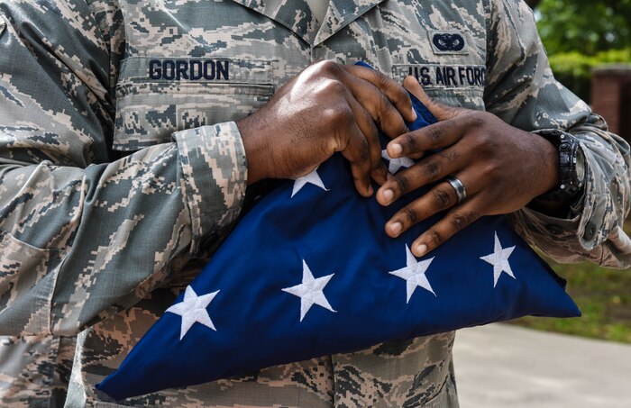 Staff Sgt. Travis Gordon, 628th Security Forces Squadron installation patrolman, holds a folded U.S. flag during a retreat ceremony May 18, 2018, at Joint Base Charleston, S.C.