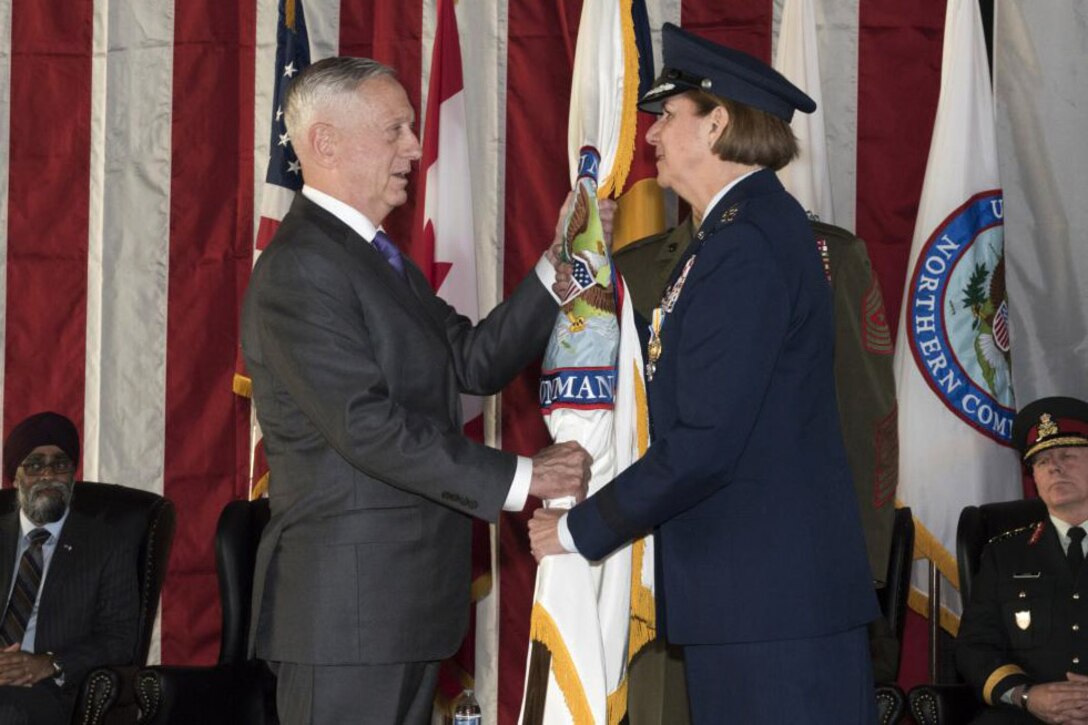 Defense Secretary James N. Mattis receives U.S. Northern Command's flag from Air Force Gen. Lori J. Robinson.
