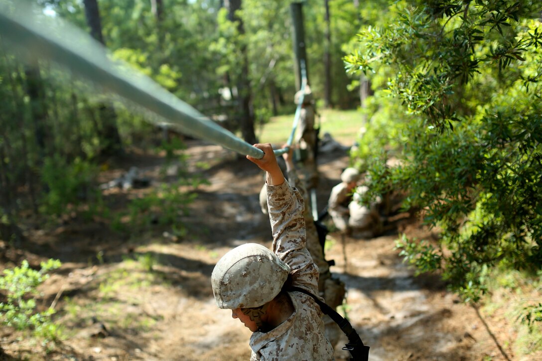 Marine Corps recruits cross an obstacle during the Crucible.