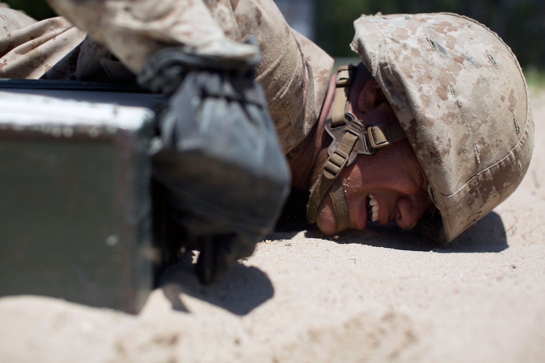 A Marine Corps recruit low crawls during the Crucible training.