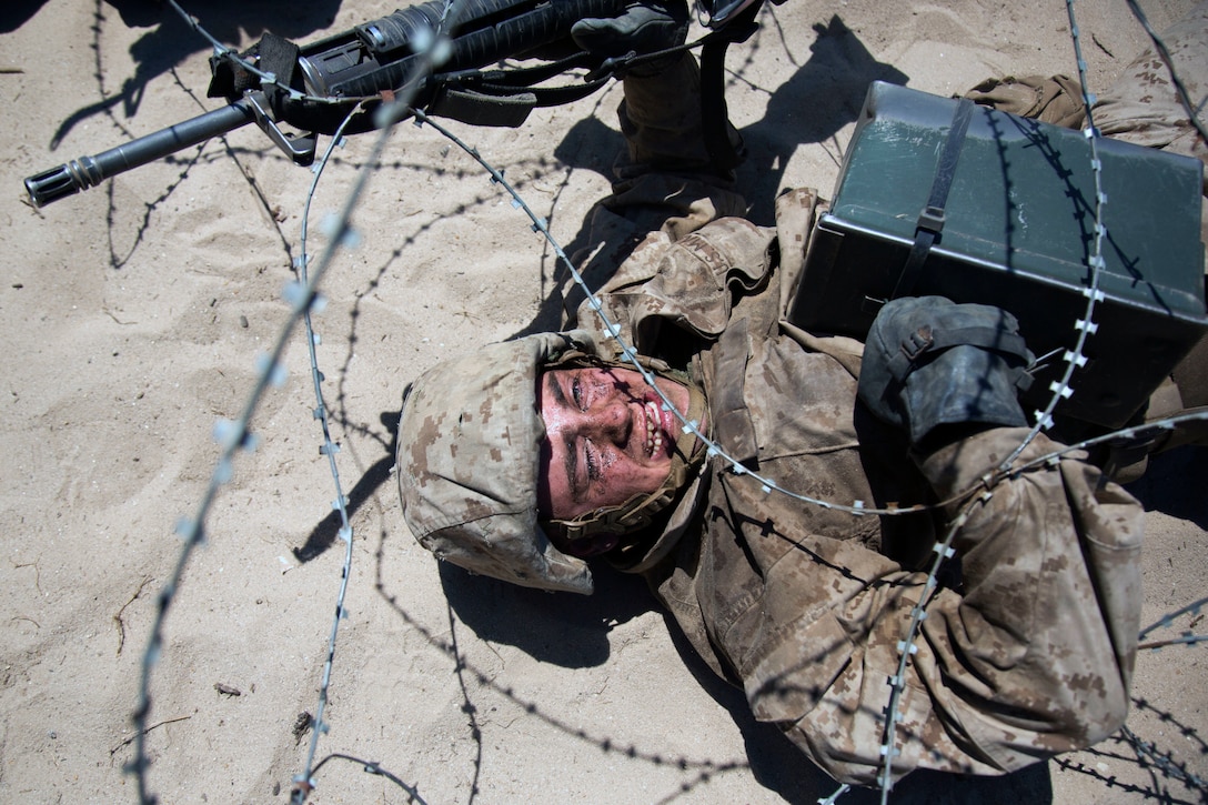 A Marine Corps recruit goes under a wire obstacle during the Crucible training.