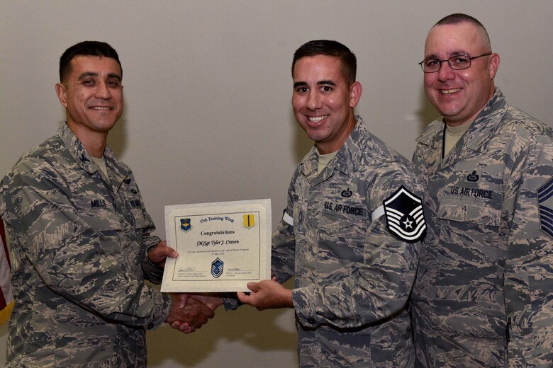 U.S. Air Force Col. Ricky Mills, 17th Training Wing commander, presents Tech. Sgt. Tyler Craven, 315th Training Squadron instructor, their certificate of selection with Chief Master Sgt. Daniel Stein, 17th TRW command chief, during a Master Sergeant release party at the Event Center on Goodfellow Air Force Base, Texas, May 25, 2018. Goodfellow held the party to notify the selected promotees and to give fellow wingmen and friends an opportunity to congratulate them on their success. (U.S. Air Force photo by Senior Airman Randall Moose)