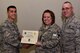 U.S. Air Force Col. Ricky Mills, 17th Training Wing commander, presents Tech. Sgt. Kendra Farmer, 315th Training Squadron instructor, their certificate of selection with Chief Master Sgt. Daniel Stein, 17th TRW command chief, during a Master Sergeant release party at the Event Center on Goodfellow Air Force Base, Texas, May 25, 2018. Goodfellow held the party to notify the selected promotees and to give fellow wingmen and friends an opportunity to congratulate them on their success. (U.S. Air Force photo by Senior Airman Randall Moose)