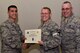 U.S. Air Force Col. Ricky Mills, 17th Training Wing commander, presents Tech. Sgt. Nathanial Hartman, 315th Training Squadron instructor, their certificate of selection with Chief Master Sgt. Daniel Stein, 17th TRW command chief, during a Master Sergeant release party at the Event Center on Goodfellow Air Force Base, Texas, May 25, 2018. Goodfellow held the party to notify the selected promotees and to give fellow wingmen and friends an opportunity to congratulate them on their success. (U.S. Air Force photo by Senior Airman Randall Moose)