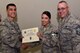 U.S. Air Force Col. Ricky Mills, 17th Training Wing commander, presents Tech. Sgt. Dulcely Hernandez, 17th TRW Protocol superintendent, their certificate of selection with Chief Master Sgt. Daniel Stein, 17th TRW command chief, during a Master Sergeant release party at the Event Center on Goodfellow Air Force Base, Texas, May 25, 2018. Goodfellow held the party to notify the selected promotees and to give fellow wingmen and friends an opportunity to congratulate them on their success. (U.S. Air Force photo by Senior Airman Randall Moose)