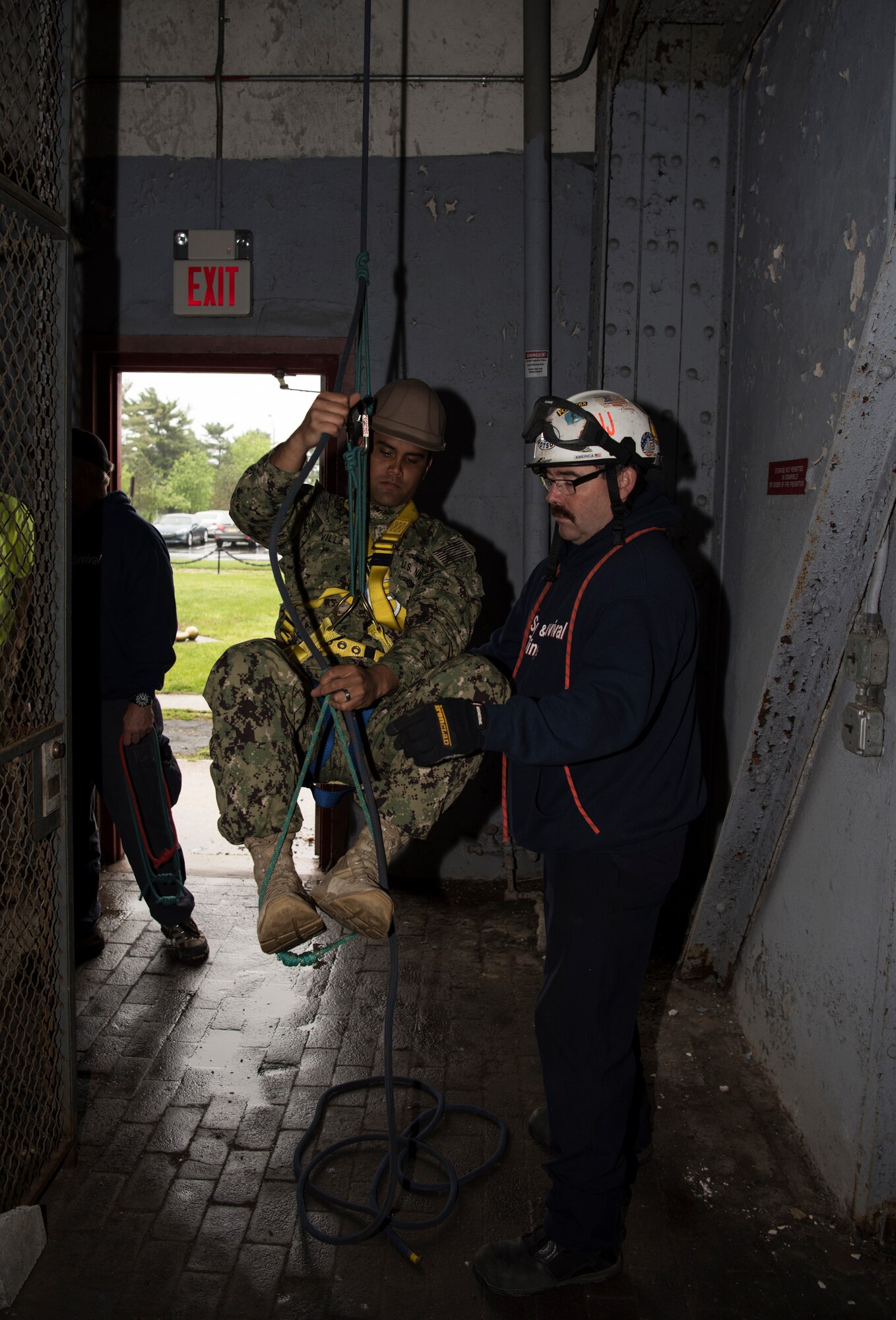 Lenny Dotson, Safety and Survival Training assistant instructor, helps a student stabilize while climbing a rope during a fall protection and prevention class on Joint Base McGuire-Dix-Lakehurst, N.J., May 16, 2018. Dotson taught the class how to properly harness themselves and climb ropes while attached. (U.S. Air Force photos by Airman Ariel Owings)
