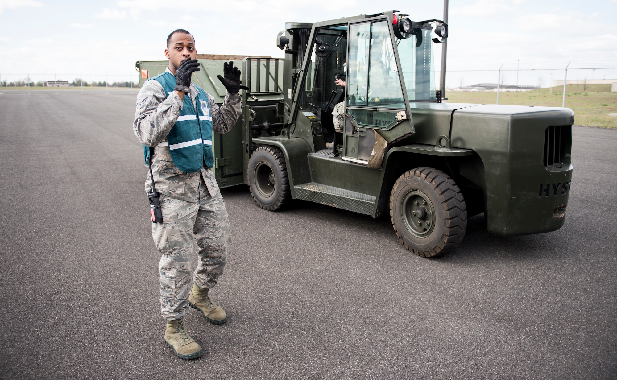 Senior Airman Diego Villanueva, 92nd Logistics Readiness Squadron petroleum, oil and lubricants journeyman, marshals a forklift during an exercise at Fairchild Air Force Base, Washington, May 2, 2018. The Cargo Deployment Function process involves more than just paperwork; it involves preparing baggage pallets, marshalling and driving forklifts, weighing and measuring cargo and checking hazardous material.  (U.S. Air Force Photo/Senior Airman Sean Campbell)