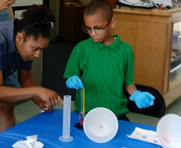 IMAGE: KING GEORGE, Va. - A local student explores the fact that all living organisms have DNA by extracting it from strawberries. He was among 14 students (and 12 parents) from Potomac Elementary School, King George Elementary School, and home schools participating in a Naval Surface Warfare Center Dahlgren Division (NSWCDD) sponsored science, technology, engineering and mathematics (STEM) event at the Dahlgren Heritage Museum, May 12. NSWCDD biomedical engineer Chelsey Lawson and Nathan Sullins, a high school junior STEM champion, mentored the second to sixth grade students who learned that strawberries have eight genome copies in every cell, making it easier to see the mass when it's extracted using dish detergent and isopropyl alcohol. 

"We take a fun twist on math by learning about statistics using starbursts," said Jon Dachos, HSI Surface Combat System Lead and STEM mentor who coordinated the event. "The students categorized and graphed the 
 contents of their candy samples and we discussed other ways that statistics are useful. Finally, the students practiced principles of physics and civil engineering by building the tallest tower they could out of dry spaghetti and mini marshmallows. In order to engage students in different STEM careers, a poster is displayed that shows potential career paths based on their STEM interests."