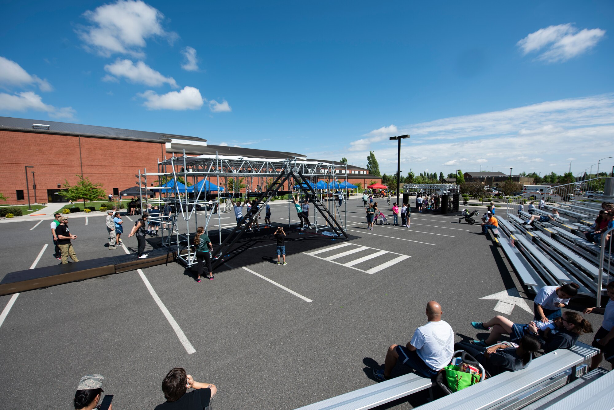 Spectators watch as participants practice training on the obstacles on the Alpha Warrior Battle Rig May 24, 2018 at Fairchild Air Force Base, Wash. The Battle Rig is 10 feet wide, 15 feet tall, 30 feet long and consists of eight obstacles to test participants strength and endurance mentally and physically. (U.S. Air National Guard photo by Staff Sgt. Rose M. Lust)